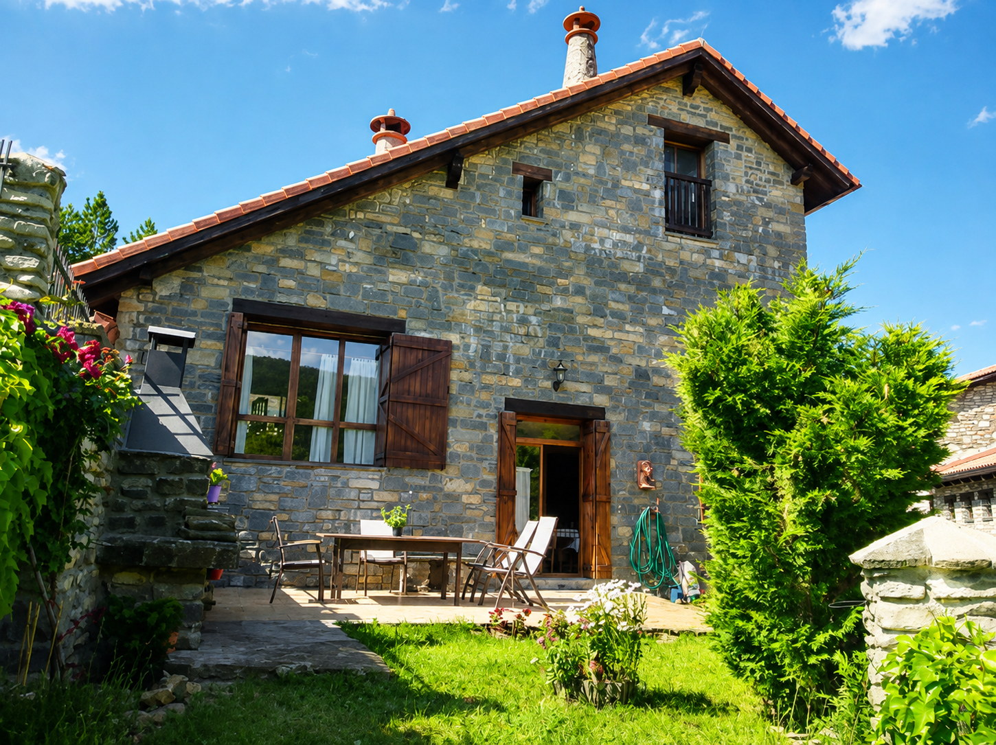 Fachada de piedra de Casa Artena con terraza y jardín en Villanovilla